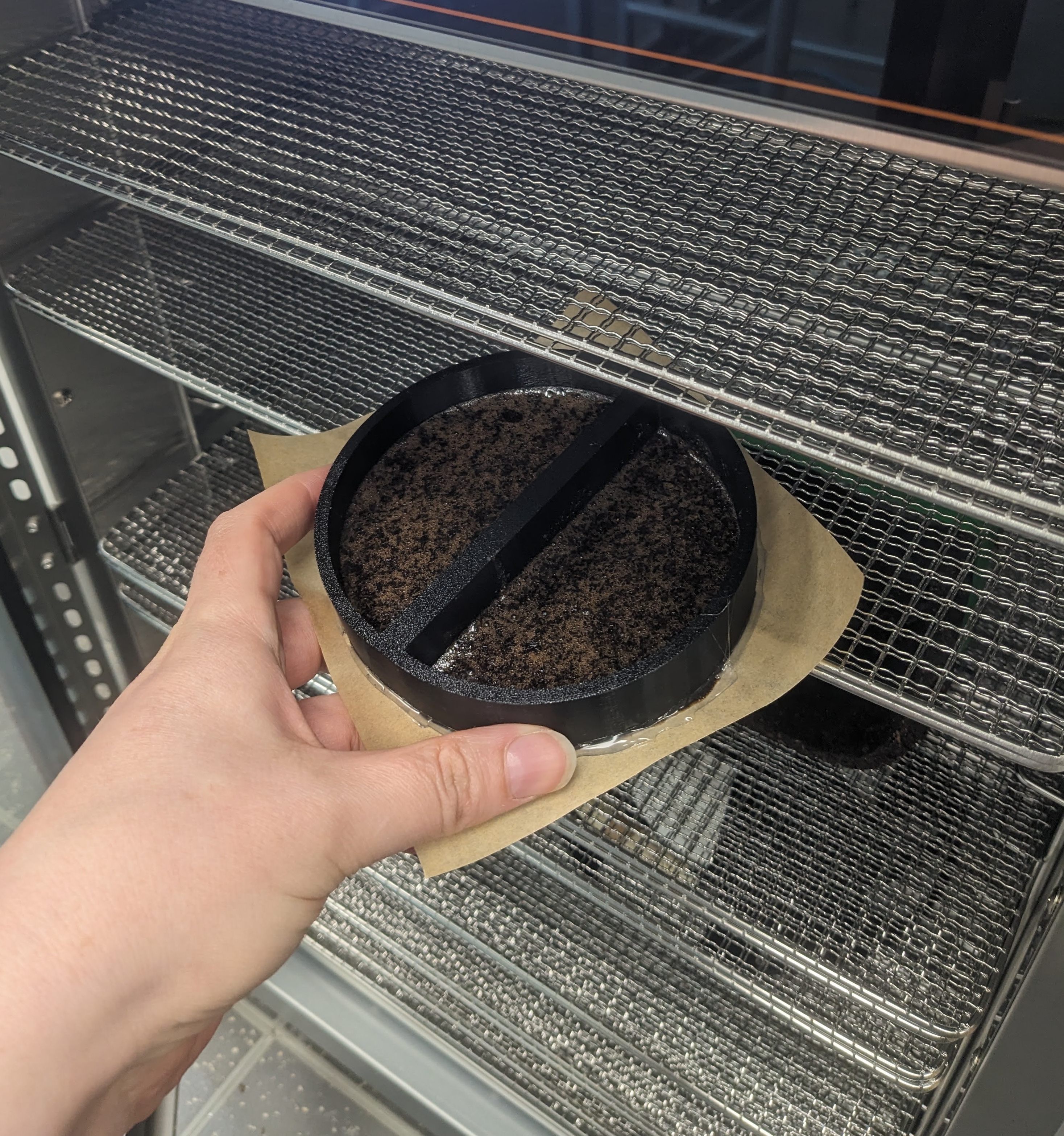 a hand holding a tray of biomaterial